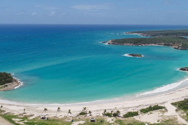 an island in the middle of a sandy beach next to the ocean